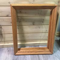 Single wooden picture frame with natural finish, 19x23 inches, showing cracked glass on one side and visible wood grain.