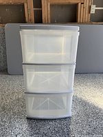 Front view showing three clear drawers and white frame