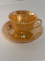 Cup on saucer, showing Peach Lustre finish and ribbed design
