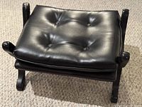 Angled view showing tufted cushion and wooden legs