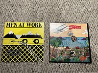 Both Men at Work album covers displayed side by side on carpet