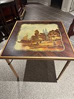 Top view of square folding table showing printed European village scene