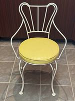 Front view of white wrought iron vanity chair with yellow cushion