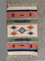 Full view of woven Southwestern-style wool rug with fringe