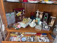 Shelf with various candles including boxed sets, pillar candles, and candle holders