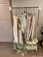 Clothing rack with various clothing items hanging on it, clothing not included.