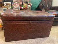 Side view of the brown leather-like ottoman showing rectangular shape and flat base.