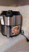 Front view of T-Fal air fryer showing stainless steel finish, model label, and XL 4.2L capacity sticker.