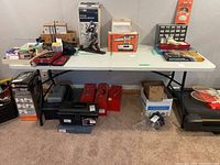 View of utility table with various items placed on top and stored underneath to show context and size.