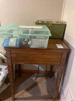 Wood cabinet closed with two sewing boxes on top.