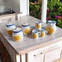 Full set of handmade hand painted sun motif kitchen pottery including 4 mugs, 3 canisters with lids, and 1 large pitcher.