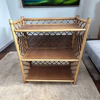 Front view of the 3 tier bamboo and rattan bookshelf on a light carpet