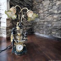 Full view of vintage figural clock with dual lamps and water fountain showing overall style and size.