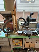 Side view of Craftsman compound miter saw and Shop-Vac vacuum positioned on workbench, showing saw blades in front of saw and hose connected to vacuum.