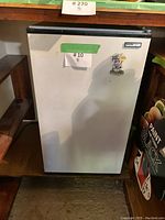 Front view of the white Danby bar fridge/freezer showing minor wear and a Lamb's sticker.