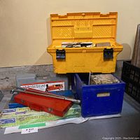 Overall view of boxes and tools showing toolbox, floor jack case, dent puller kit, and blue box with accessories.
