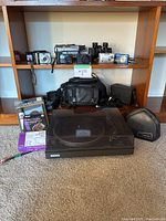 Front view of full lot showing turntable, accessories and items on shelf