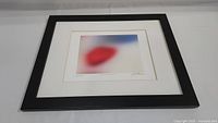 Full framed artwork showing the black frame and white matting with the abstract watercolor.
