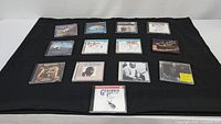 14 Big Band and Jazz artist CDs arranged on a black cloth showing front covers and jewel cases.
