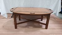 Front angle view of the oval wooden Ethan Allen coffee table showing its legs and support structure.
