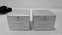 Two Apeiro Timeless Beauty skincare products, Advanced Deep Moisturizer and Advanced Deep Facial Peeling, in silver and white boxes.