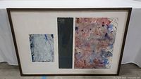 Full view of the framed abstract artwork showing three mixed media sections in a brown frame and white mat.