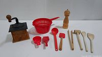 Photo of Colonial Coffee Mill alongside various kitchen tools including plastic and wooden items