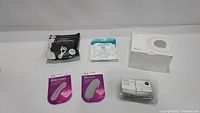 Various personal care items including Nooro foot pads, facial cleansing cloths, heel liners, masks, and a USB light box