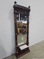 Full view of tall antique Victorian pier mirror showing overall frame, mirror glass, and marble ledge at the base.