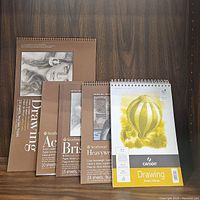 Photo of all five pads stacked showing covers and brands.