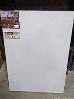 Front view of the 24x36 white stretched canvas with labels.