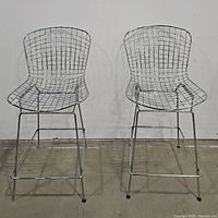 Pair of metal wire bar stools placed side by side, showing front view with full height and width visible