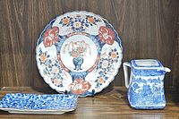 Full set of three ceramic items displayed on wooden shelf: charger plate, teapot, and trinket tray.