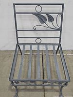 Front view of wrought iron patio chair with leaf detail on backrest