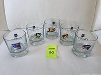 Front view of 5 NHL team logo glass tumblers: New York Rangers, Pittsburgh Penguins, Anaheim Ducks, Phoenix Coyotes, Columbus Blue Jackets.