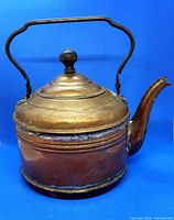 Front angle view of copper kettle with lid on showing patina, soldering and dents.