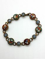 Top view showing front side of vintage micro mosaic floral tile bracelet with gold-tone metal links and colorful floral tiles.