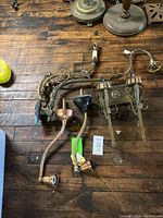 Overview of assorted sconces and wall lights on wooden surface showing various styles and materials including copper and brass finishes.