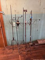 Lot of six early 20th century adjustable bridge and floor lamps standing together against a wall.