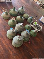 Overall view of green enamel lamp shades and plastic bin with fixtures