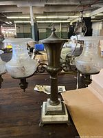 Full front view of two-light bronze and marble Argand lamp with glass shades