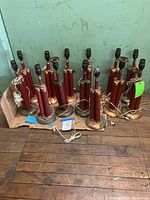 Wide view of all 13 lamps on cardboard against wall