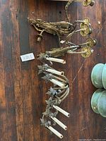 The pair of bronze 3-arm wall sconces stacked with the single large 7-arm iron wall sconce nearby on a wooden floor. Candle holders visible on all sconces.