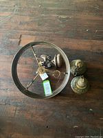 Top view showing circular metal frame, mechanical parts, and two separate glass holders on a wooden floor