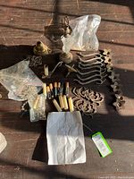 Photo of all chandelier parts laid out including brass arms, candle covers, crystal beads and pendants, and base with central crystal body.