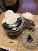 Closed view of Tefal ActiFry air fryer, Rival electric kettle, and air fryer basket on table.