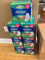 Seven stacked boxes of Always Ultra Thin feminine pads, each box contains 88 pads with long wings and LeakGuard protection.