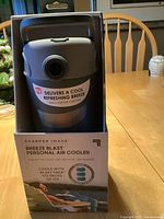 Front view of the Breeze Blast personal air cooler in packaging showing brand, product name and 'As Seen on TV' logo along with key feature label that mentions it delivers a cool refreshing breeze.