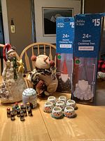 Overview of the Christmas lot showing the ceramic and fabric snowmen, wooden igloo with penguins, tea lights, and boxed gnome Christmas trees.