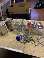 Overview of all items laid on table showing napkin holders, sugar holders, corkscrews, ketchup bottle, and metal utensils